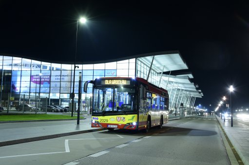 zdjęcie przedstawia autobus gminnej komunikacji przed budynkiem Portu Lotniczego we Wrocławiu