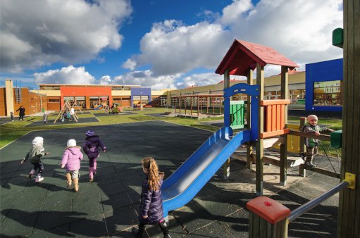 zdjęcie przedstawia dzieci bawiące się na placu zabaw przy przedszkolu