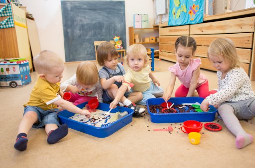 zdjęcie przedstawia sześcioro przedszkolaków bawiących się ciastoliną