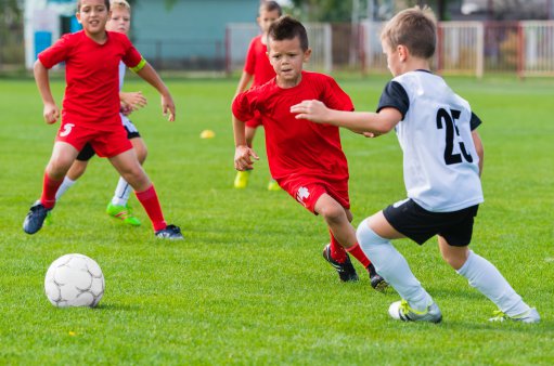 zdjęcie przedstawia młodych chłopców grających w piłkę nożną