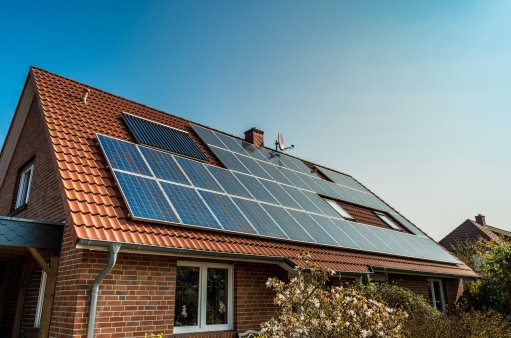 zdjęcie przedstawia budynej jednorodzinnyz panelami słonecznymi na dachu