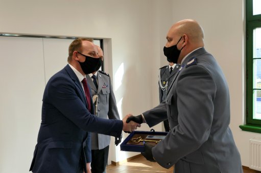 Na zdjęciu Burmistrz Łukasz Zbroszczyk przekazuje policji klucze do posterunkuu